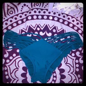 Luli Fama teal bathing suit bottoms.